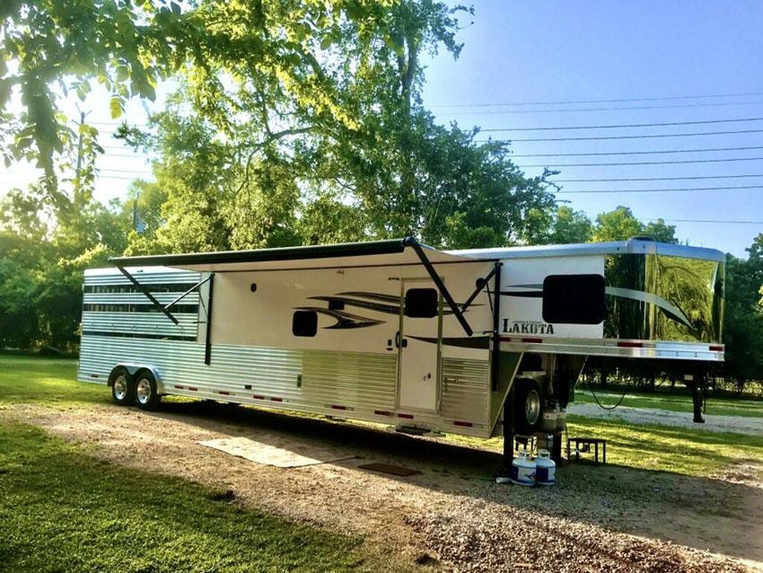 Lakota horse trailer with awning parked on gravel at Sugar Land RV Park