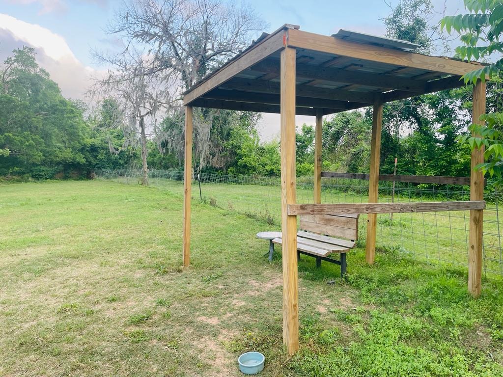 Wooden pergola with bench seating at Sugar Land RV Park