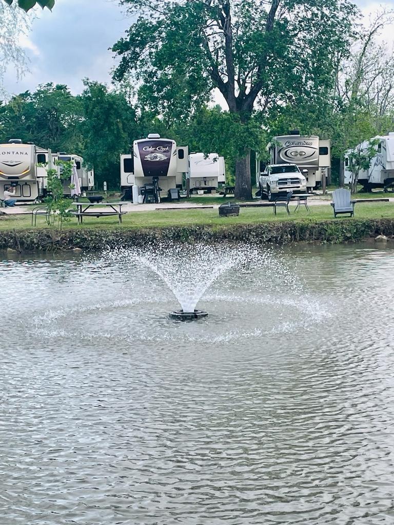 Pond fountain with Cedar Creek and Columbus RVs in background at Sugar Land RV Park