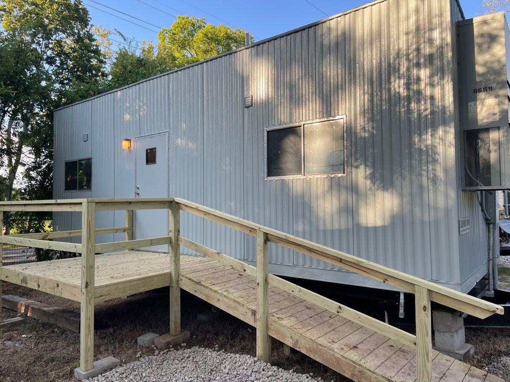 Restroom and shower building exterior with wooden ramp at Sugar Land RV Park