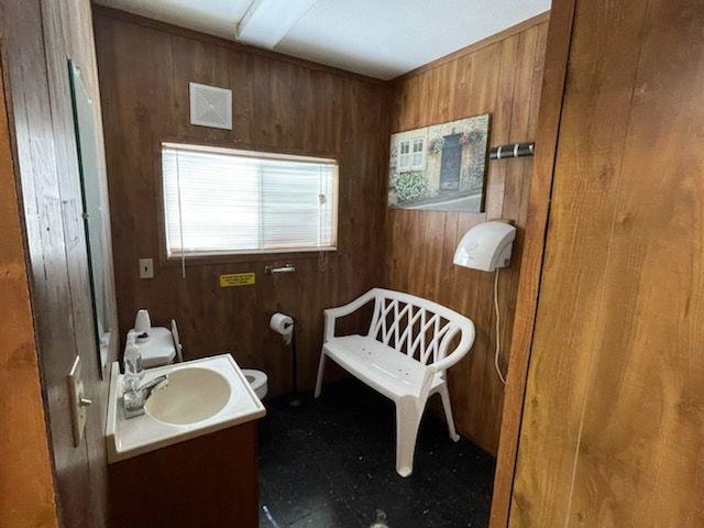 Clean restroom interior with sink and seating at Sugar Land RV Park
