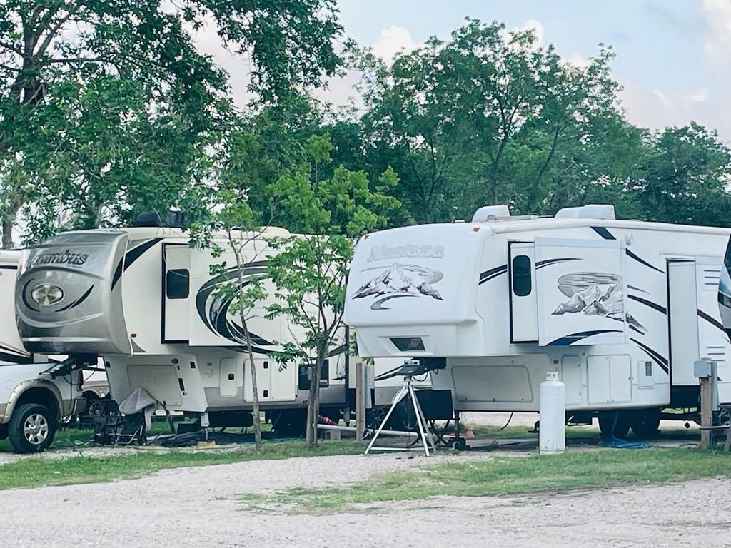 Two large fifth-wheel RVs parked side by side at Sugar Land RV Park